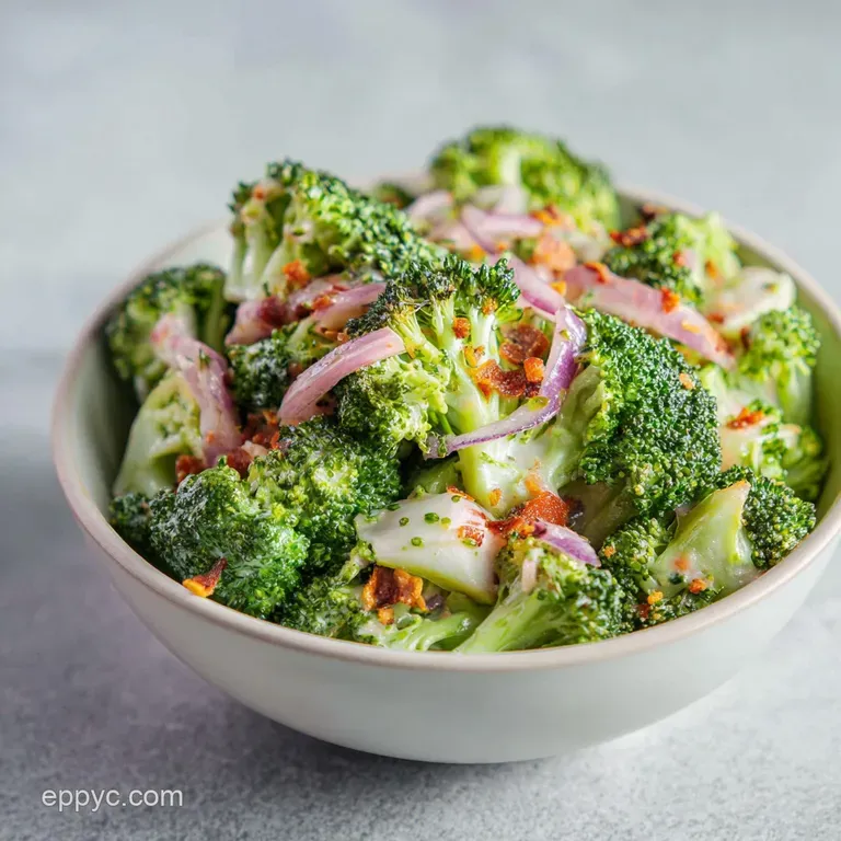 Broccoli salad elegantly plated, creamy dressing glistening, topped with toasted slivered almonds and vibrant red cranberr...