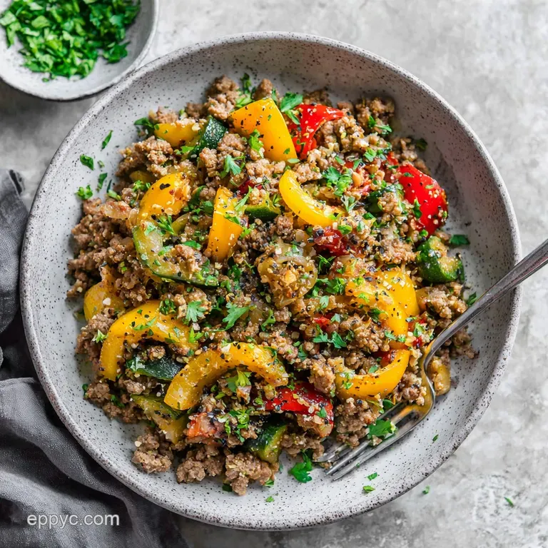 Close-up of a perfectly plated stir-fry with fresh herbs, showcasing the juicy beef and bright veggies in a shallow bowl.