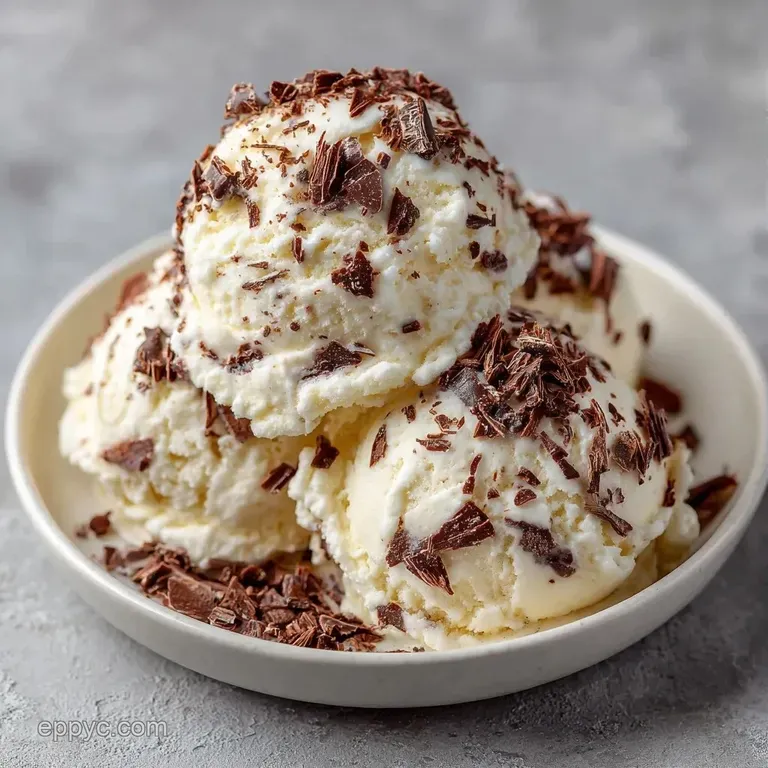 Elegant clear glass containing swirls of dark espresso and white cream, paired with a small silver dessert spoon.